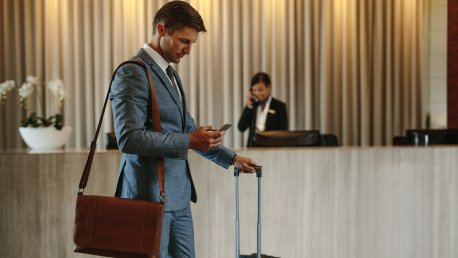 Työmatkustaja selaamassa S-Business -mobiilia Radisson Blu Hotellin aulassa