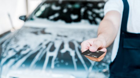Yrittäjä ojentaa S-Business -yrityskorttia ABC Autopesussa